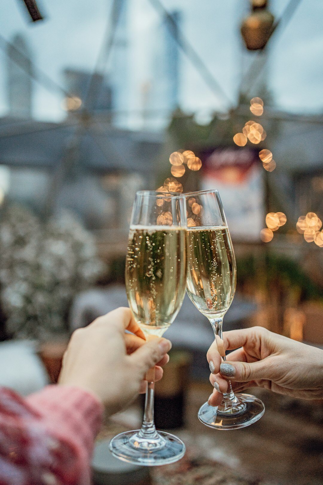Hands toasting with champagne glasses at a golden celebration event